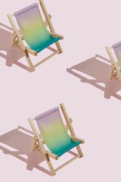 Patroon van mini kleurrijke strand ligstoel met scherpe schaduw tegen roze achtergrond Creatief zomerconcept met een kopie ruimte Minimale ontspanning en vakantie idee Herhaling idee
