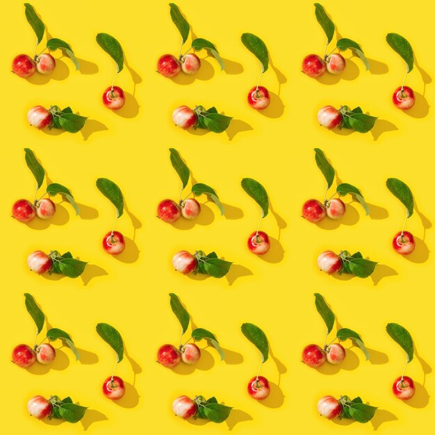 patroon van rijpe kleine rode appels en groene bladeren op gele kleur Food concept Vegetable