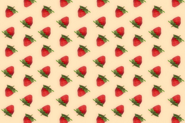 Patroon van verse mooie aardbeien geïsoleerd op romige kleur achtergrond. bovenaanzicht foto concept