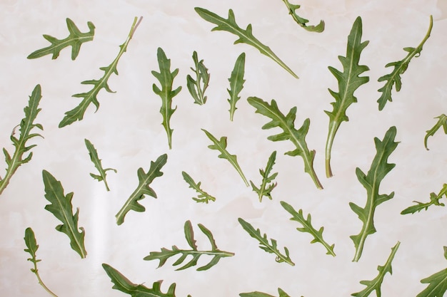 Photo pattern of arugula leaves on a marble background creativ food concept flat lay