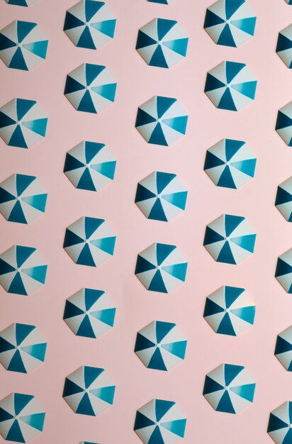 Photo pattern of blue umbrellas over a pastel pink background, minimalism, design and digital resource, background with copy space