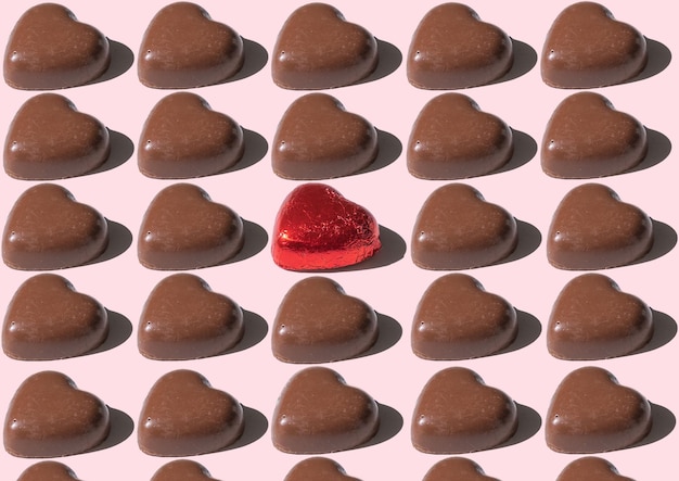 Pattern of chocolate bars shape heart against pink background