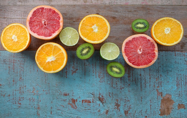 Pattern of citrus orange grapefruit lemon lime fruit and kiwi on the wooden background