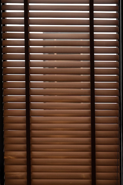 Pattern of closed brown wooden blinds in the office