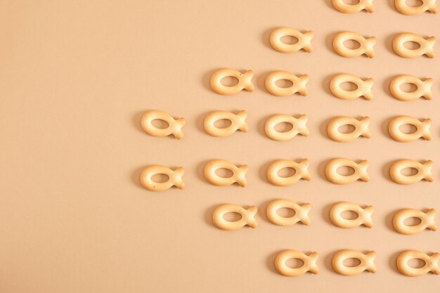 Pattern of cookies in the shape of a fish on a beige background