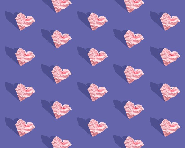 Photo pattern - crumpled paper hearts on a purple background, color of year 2022 very peri. seamless background with hearts, hard light. creative pattern, trend, minimalistic background, hard shadows.