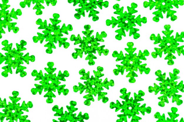 A pattern of decorative green snowflakes on a white wall