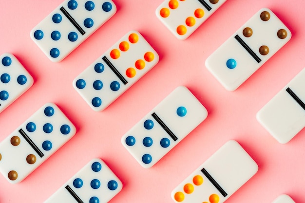 Foto un modello di pezzi di domino su sfondo rosa