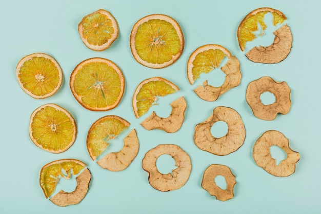 A pattern of dried orange and apple rings on turquoise