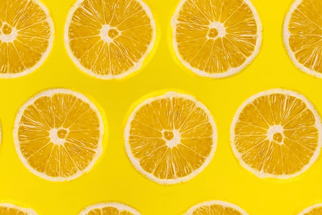 Pattern of fresh sliced lemon on yellow background. Lemons fruits. Juicy slice of lemon on yellow background.