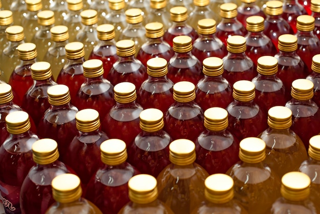 Pattern of glass bottles with colorful drink in the Kombucha manufacturing process