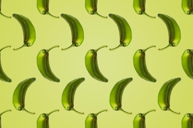 Pattern of green peppers isolated on light green background Creative photo of peppers aligned