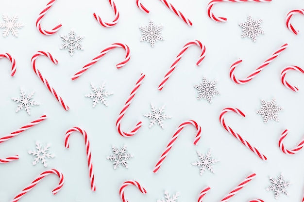 Pattern of hard candy cane striped in Christmas colors on baby blue background.