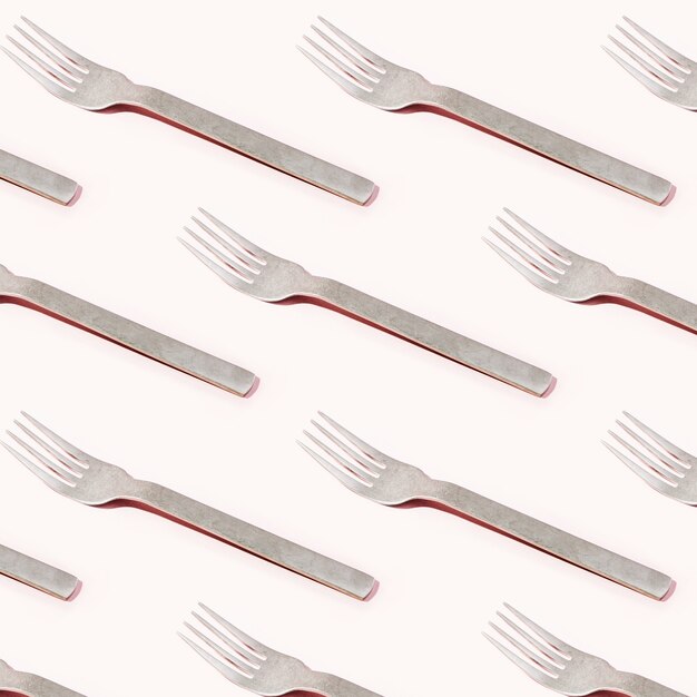 Pattern made of cutlery on pastel background, flat lay, top view. Fashion Minimalist concept.