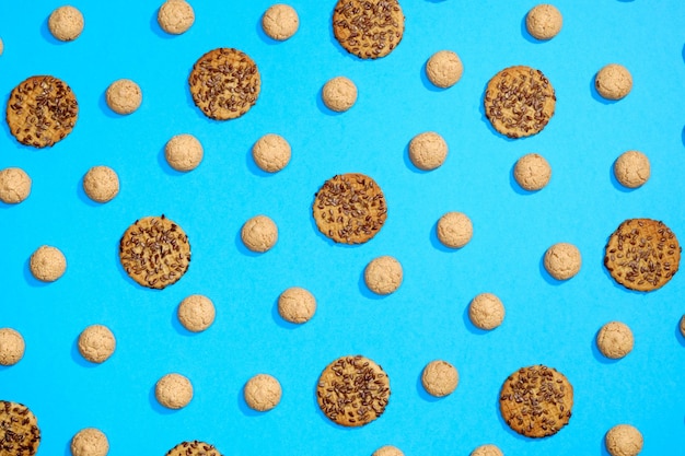 Pattern made of sweet cookies on blue background Flat lay