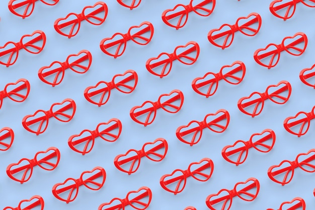 パステルカラーの背景に赤いハート型のサングラスで作られたパターンバレンタインデーのコンセプト