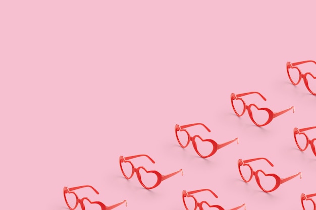 Foto disegno realizzato con occhiali da sole a forma di cuore rosso su sfondo di colore pastello