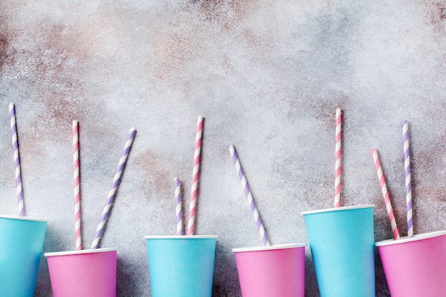 Photo pattern of pink and blue paper cup of coffee on old light surface.  flat lay.