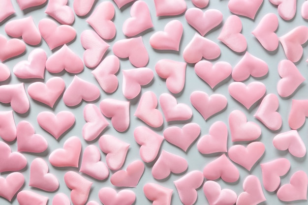 Photo pattern of pink romantic hearts on blue background. valentine's day texture. love concept.