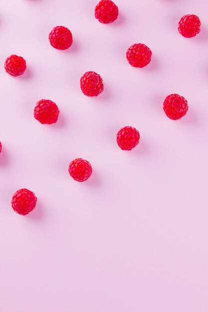 Pattern of raspberries on pink background Colorful diet and healthy food concept