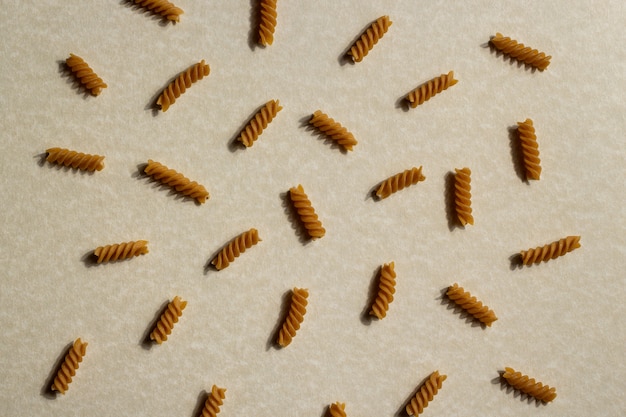 Photo pattern of raw italian pasta on brown