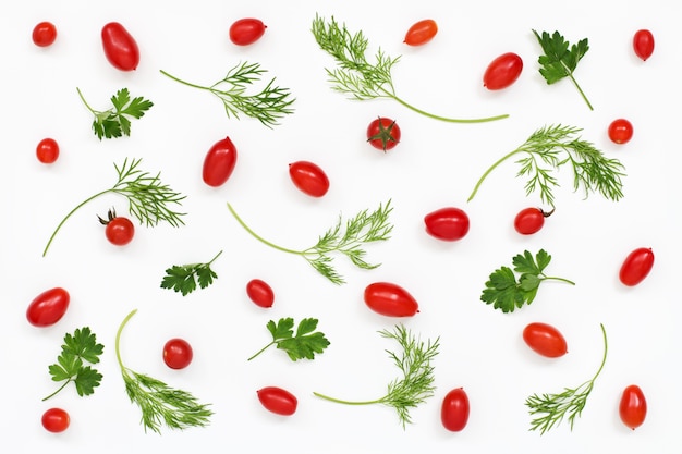 Pattern of red tomatoes, parsley and dill on white surface