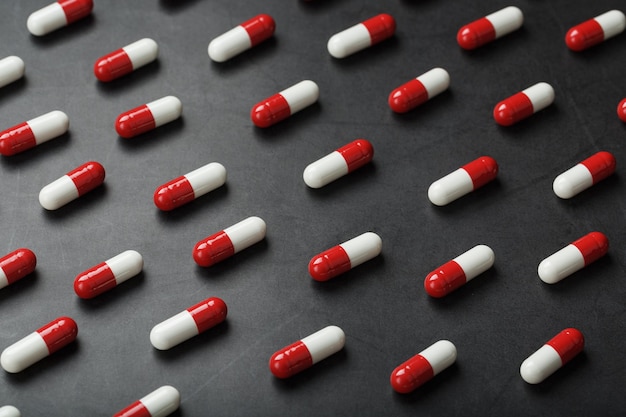 A pattern of red and white pill capsules on a black background background