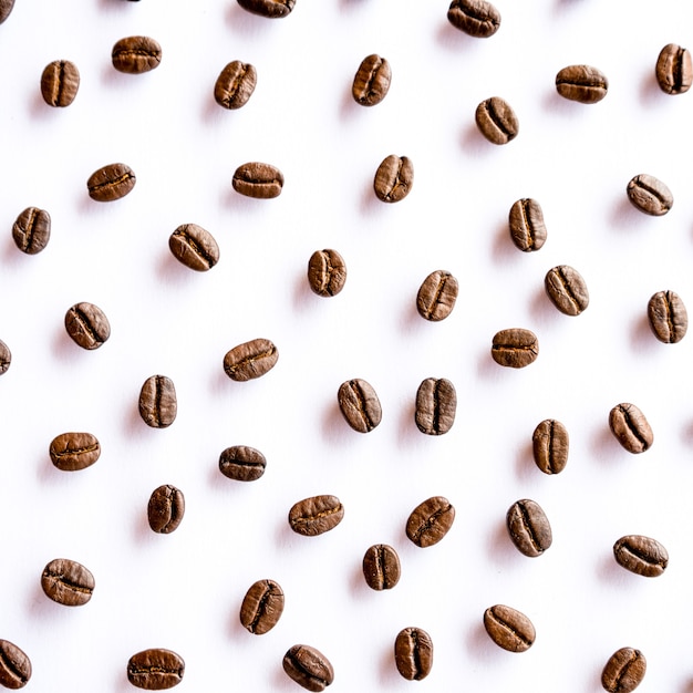 Pattern of roasted coffee beans arrange on white background