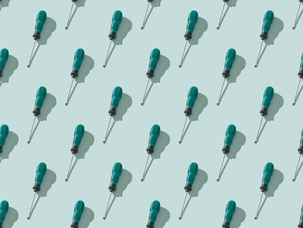 A pattern of screwdrivers on a light blue background.