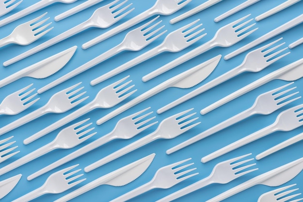 Pattern, template, background, studio shot. Ornorazovye white plastic knives and forks.