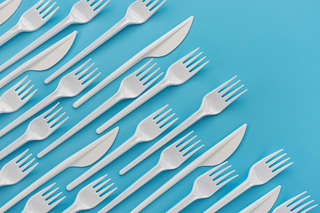 Pattern, template, background, studio shot. Ornorazovye white plastic knives and forks