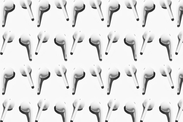 Photo pattern of wireless earphones isolated on white background.