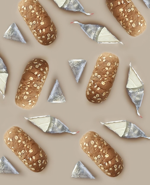 Pattern with bread buns and processed cheese on beige background