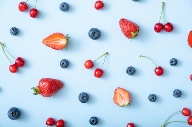 Modello con fragole ciliegie e lamponi su sfondo blu