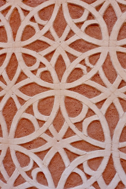 Patterned finishing on red rough wall outside in Segovia Spain Arabic motif oriental ornate