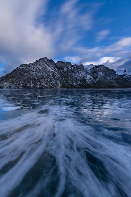 Patterns in the ice of Lake Minnewanka with Mount Inglismaldie in Banff National Park in the backgro