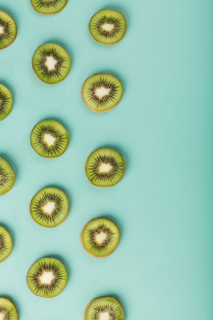 Photo the patterns of the slices of kiwi fruit on green surface