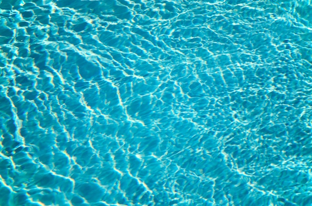 Patterns of sunlight rippling o n a swimming pool water surface