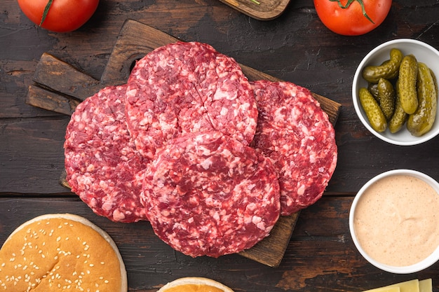 Tortino di carne macinata per set di hamburger, sul vecchio tavolo di legno scuro dark