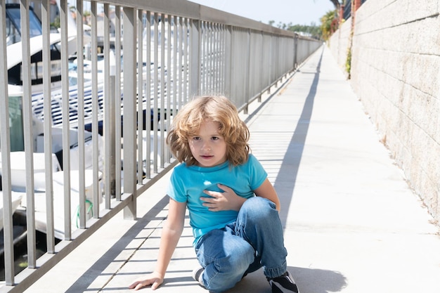 息を止めた。少年は遊歩道に腰を下ろしてリラックスします。男の子の子供は少し休憩します。少年時代と子供時代。夏休み。