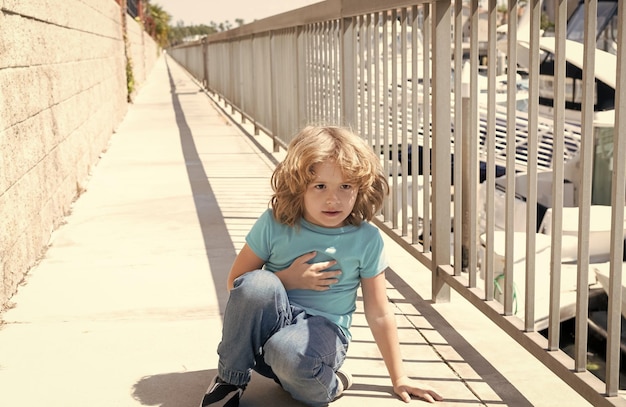 Paused for breath Boy relax hunkering down on promenade Boy child take short rest