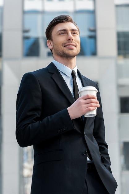 Pauze hebben. Portret van een jonge zakenman die 's ochtends koffie buiten drinkt