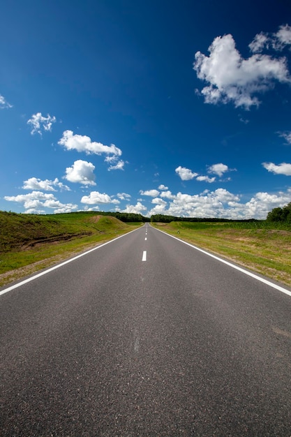 Foto strada asfaltata con cielo azzurro e nuvole