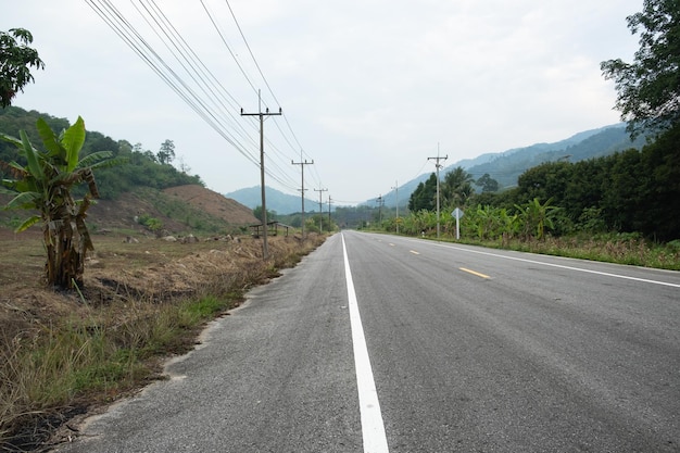 Paved road ThailandThe asphalt road on both sides of the road is covered with grass