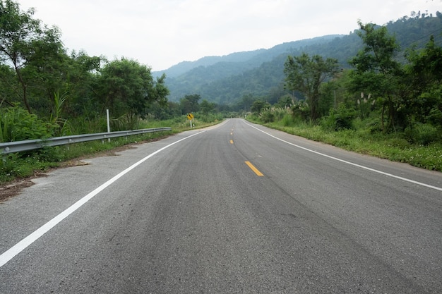 Paved road ThailandThe asphalt road on both sides of the road is covered with grass