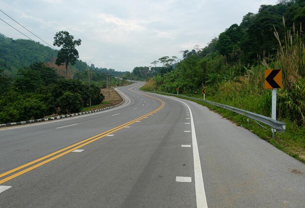 Paved road ThailandThe asphalt road on both sides of the road is covered with grass