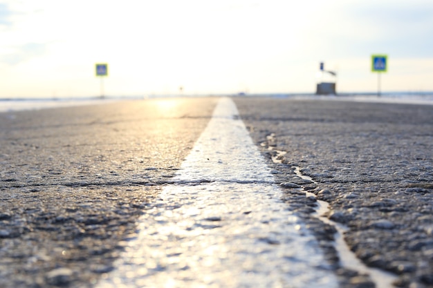 paved road in winter at sunset