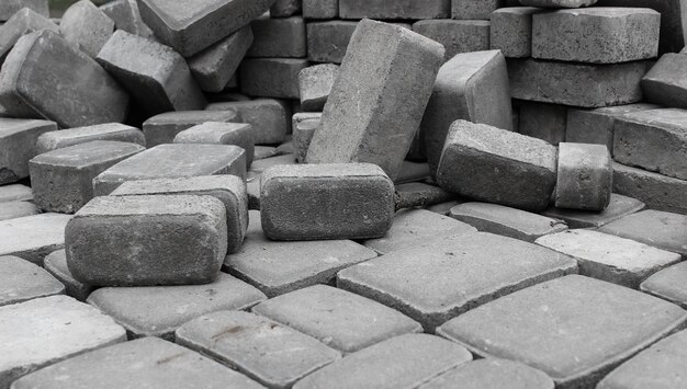 Photo pavement tiles laid out on a flat surface in front of a pile of similar tiles low point of view