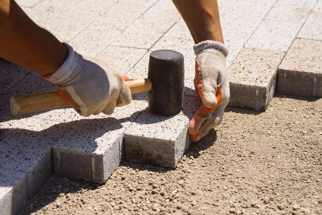 Paver sta posando pietre per lastricati posa lastre di cemento