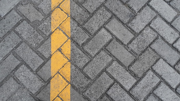 Lastra di pavimentazione grigia strada urbana con linee gialle segnaletica orizzontale pietra piastrelle texture di sfondo